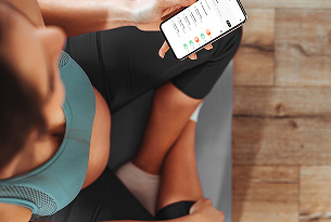 Deportista joven interactuando con el pilates booking system Tecnofit en su teléfono móvil